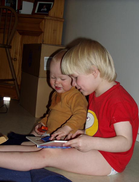 Harald läser för Artur medan mamma fyller en pafflåda